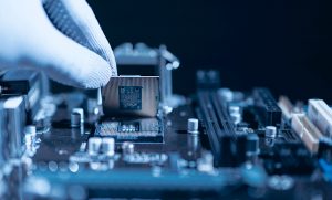 Technician installing semiconductor processor onto PCB during domestic electronics manufacturing and embedded systems assembly